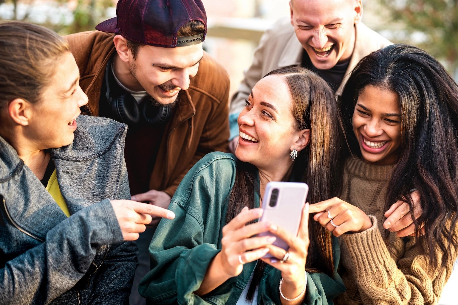 menschen die freudig auf ein smartphone schauen